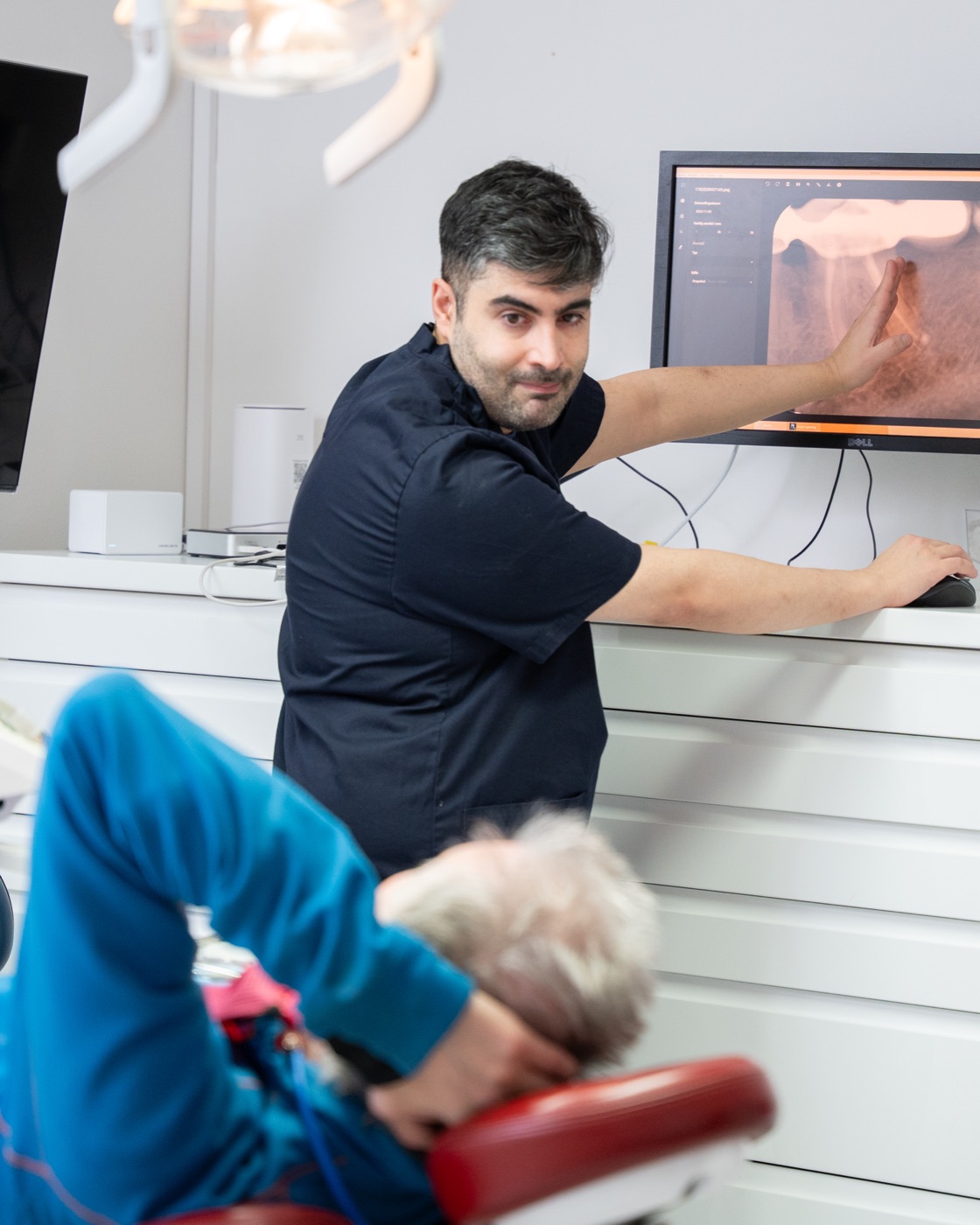 Tandläkaren Saman går igenom en röntgenbild med en patient